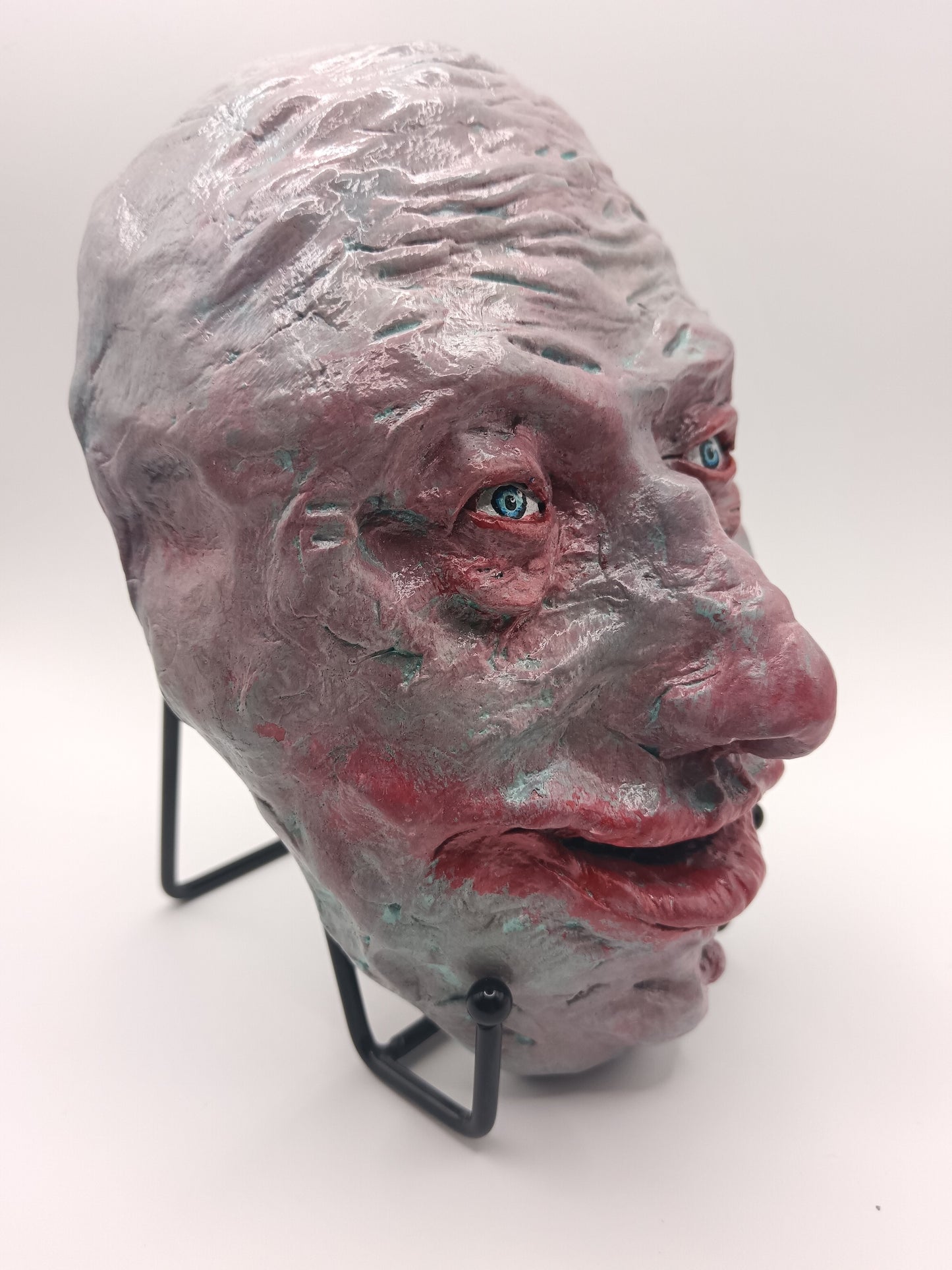 creepy grinning hand sculptured horror sculpture with stand side