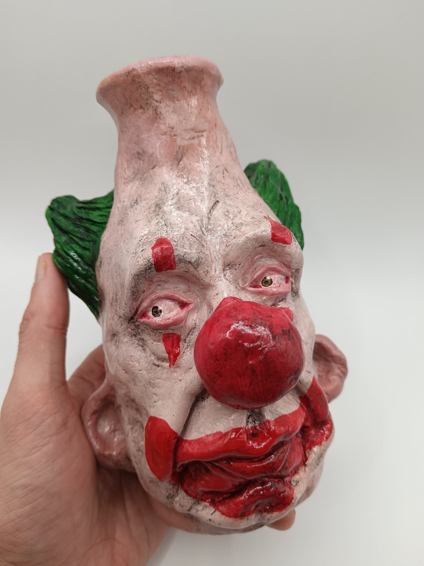 Handmade clown vases with green hair in hand
