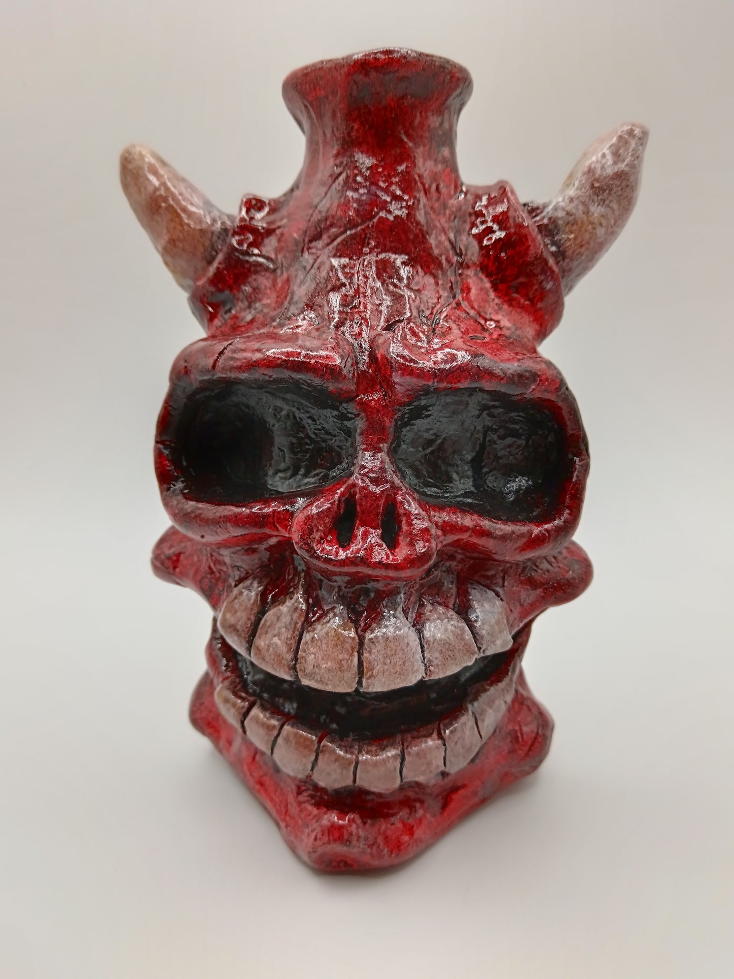 Hand made clay red skull vase with horns front view