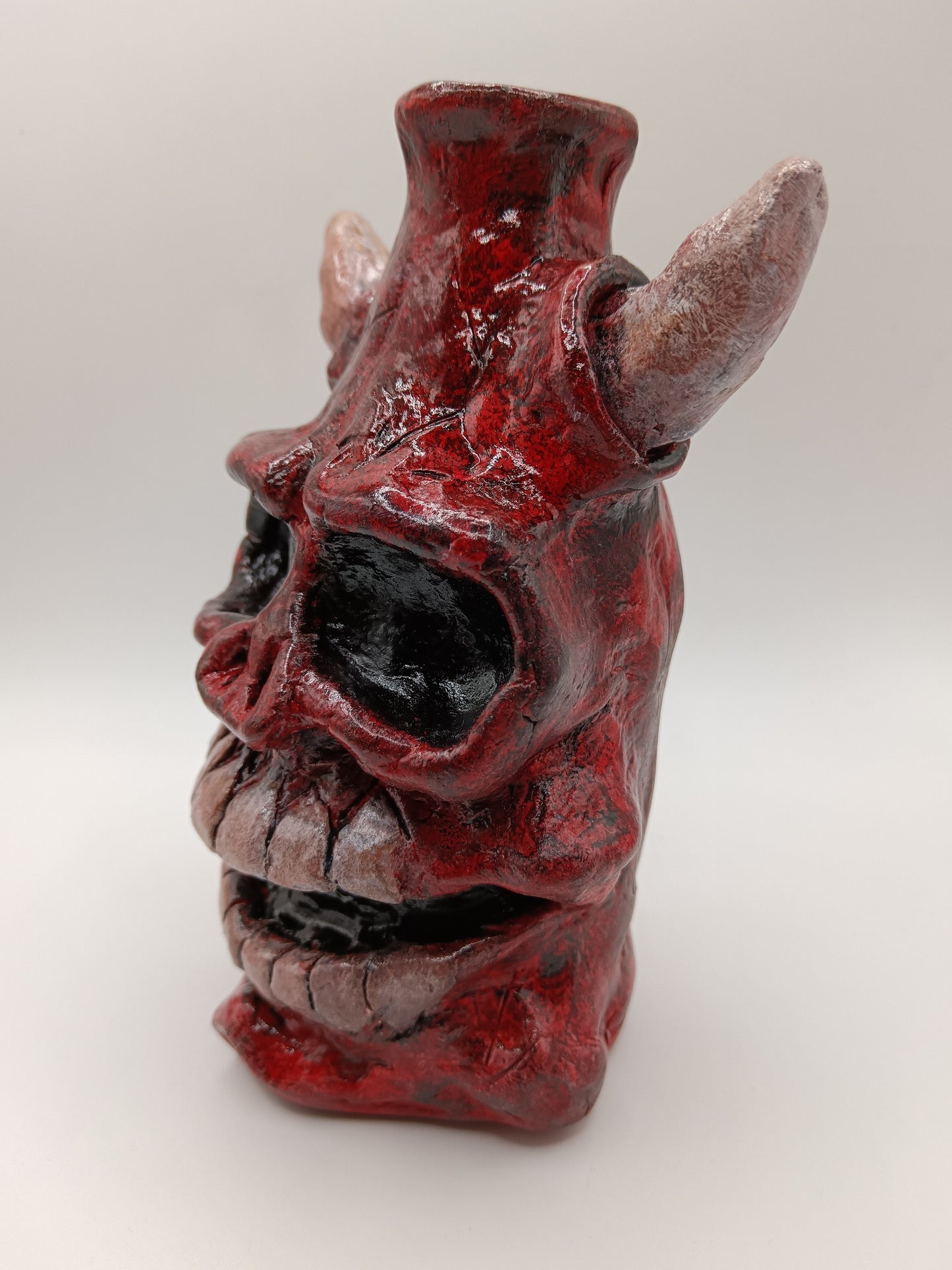 Hand made clay red skull vase with horns side view
