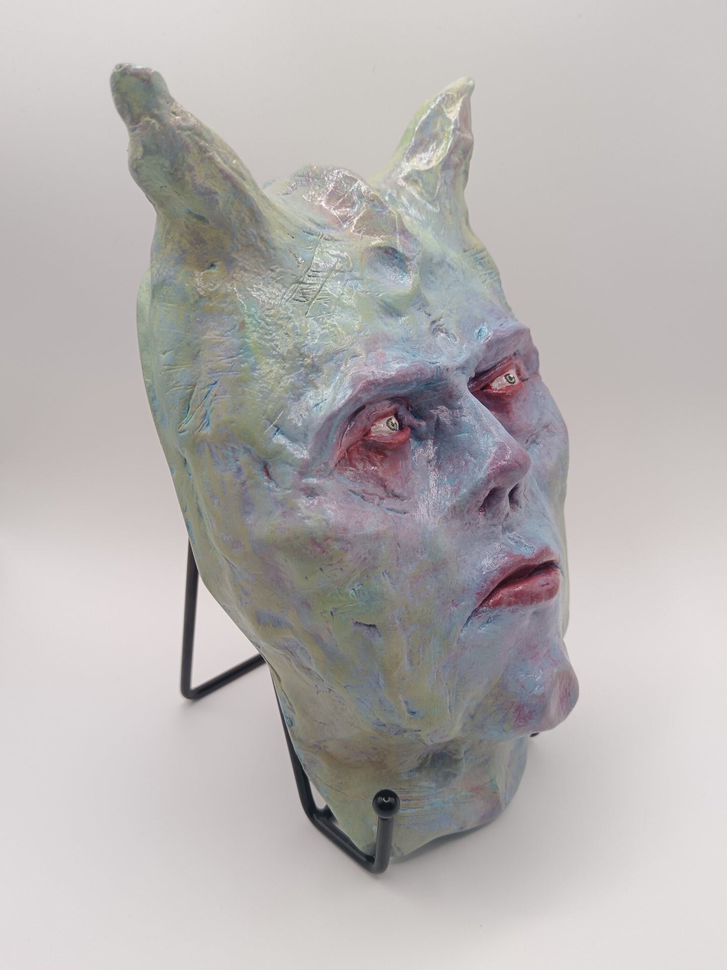 Hand sculpted clay pastel demon sculpture with stand front side
