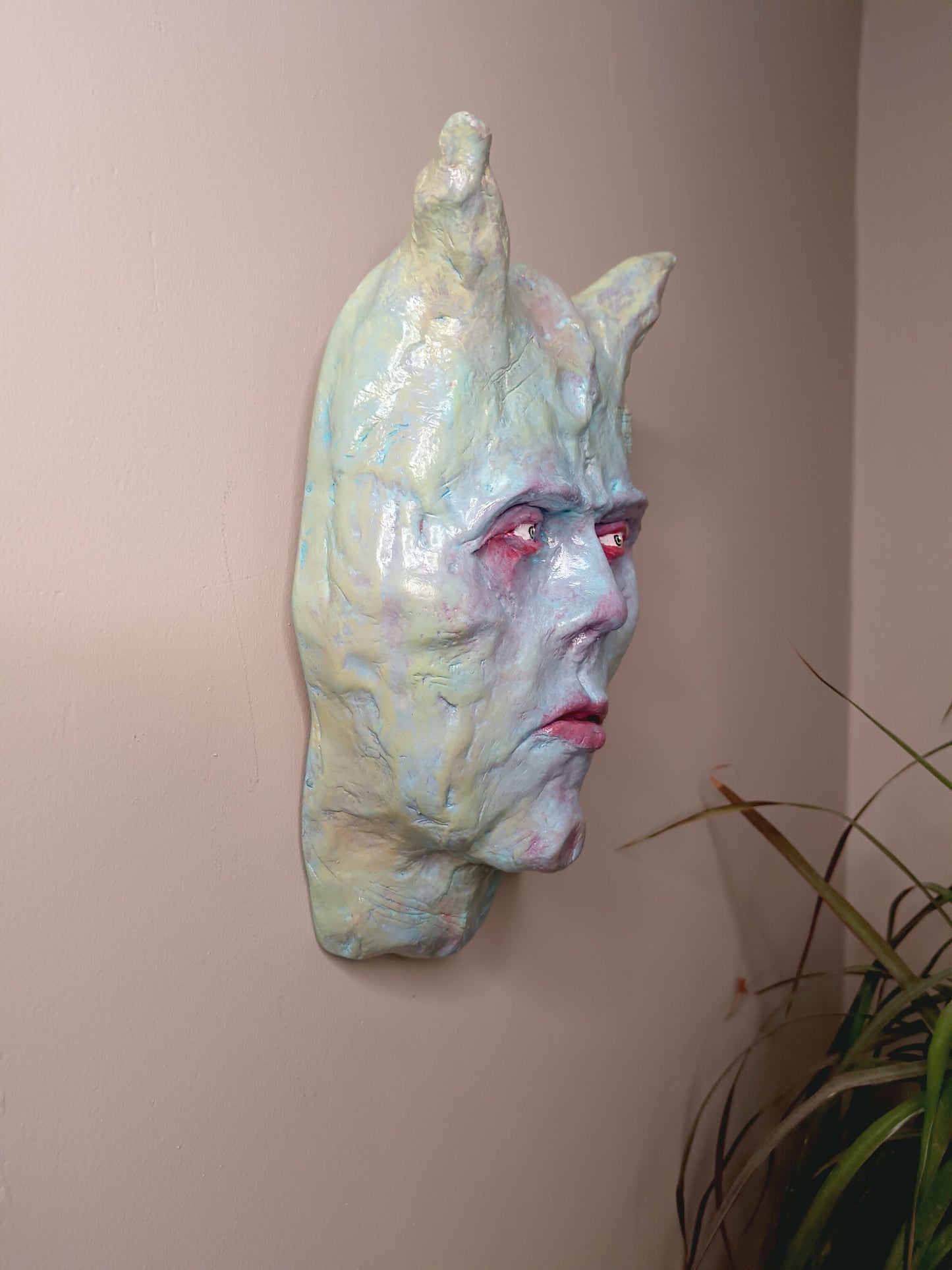 Hand sculpted clay pastel demon sculpture wall hanging side