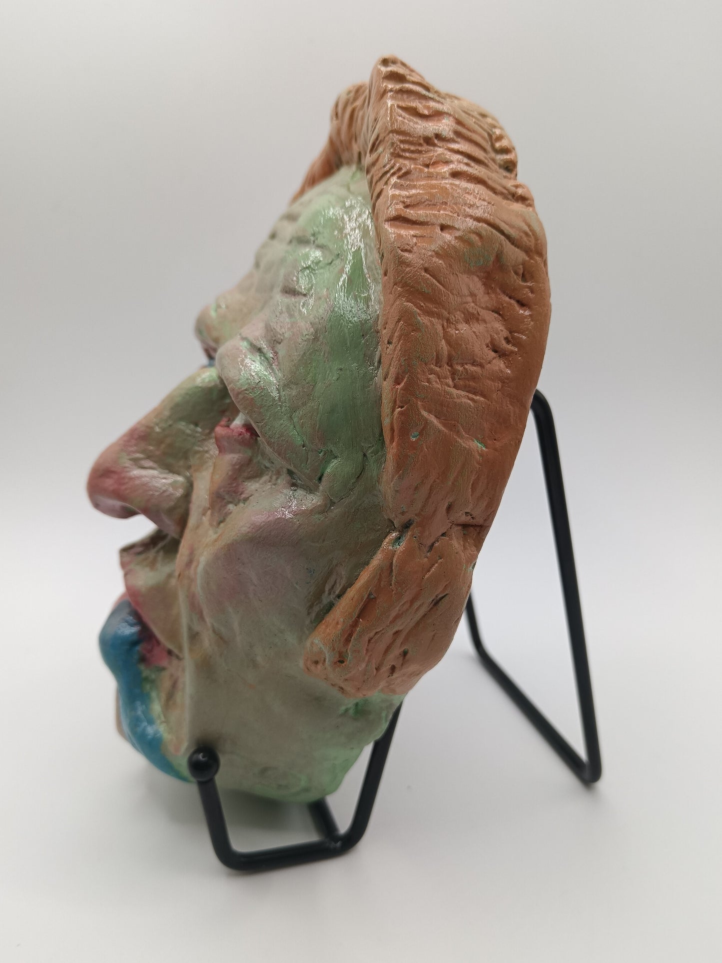 hand sculpted lizard man clay sculpture with stand left view