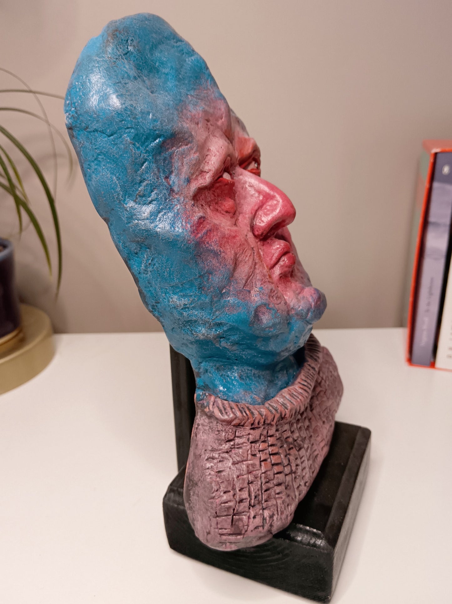 handmade clay alien sculpture, home setting side view