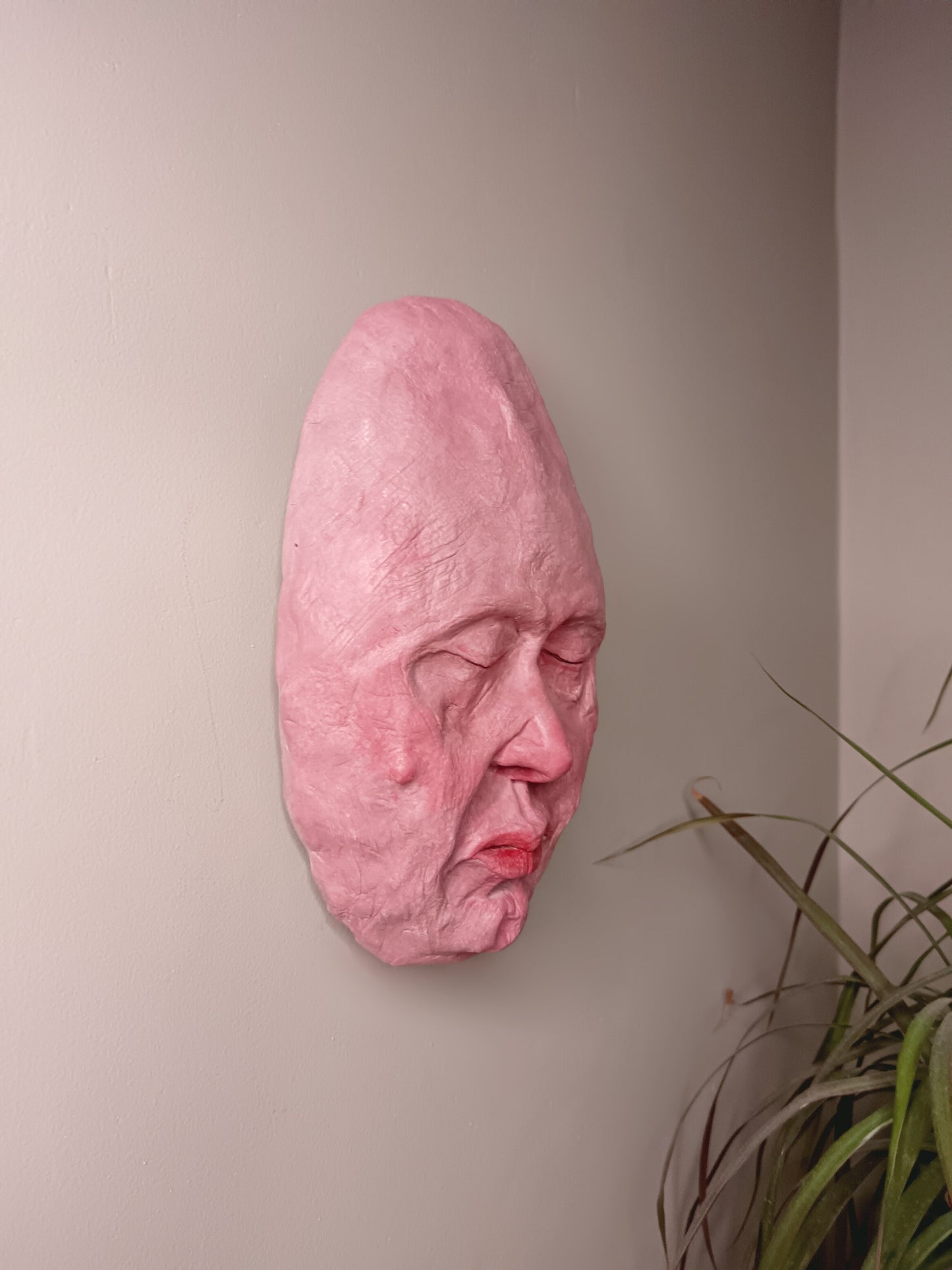 hand sculpted egghead sculpture, wall mounted side view