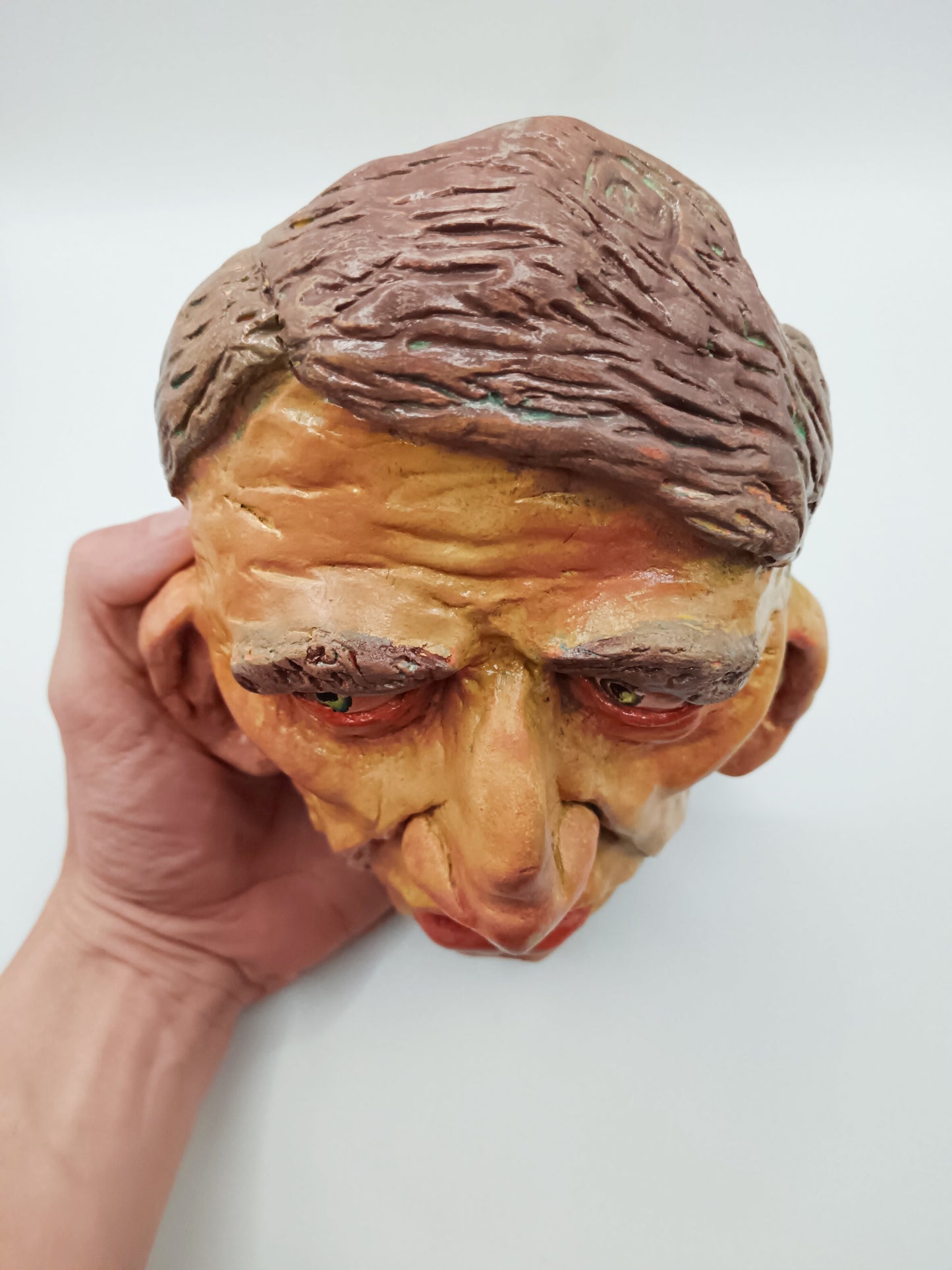Hand sculpted clay yellow face mask sculpture top view