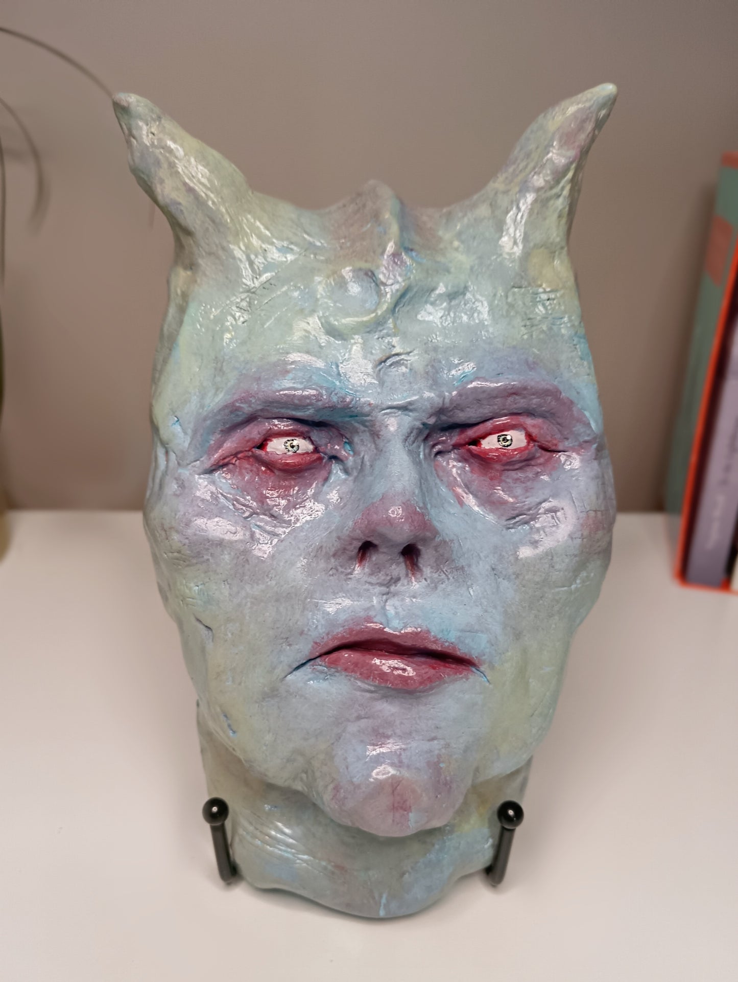 Francis underwater Monster mask with red eyes and horns on a white surface