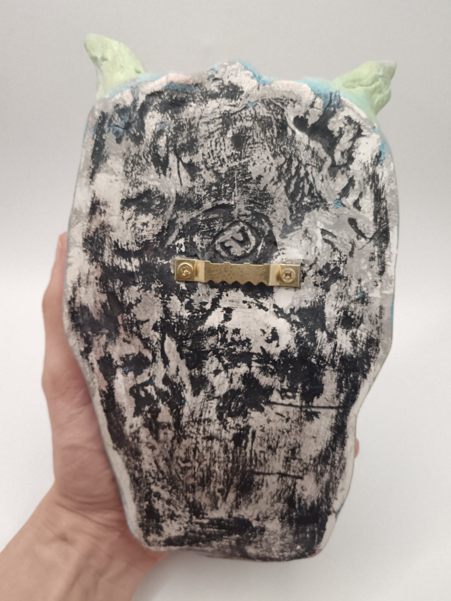 back of devil sculpture with sawtooth hanger