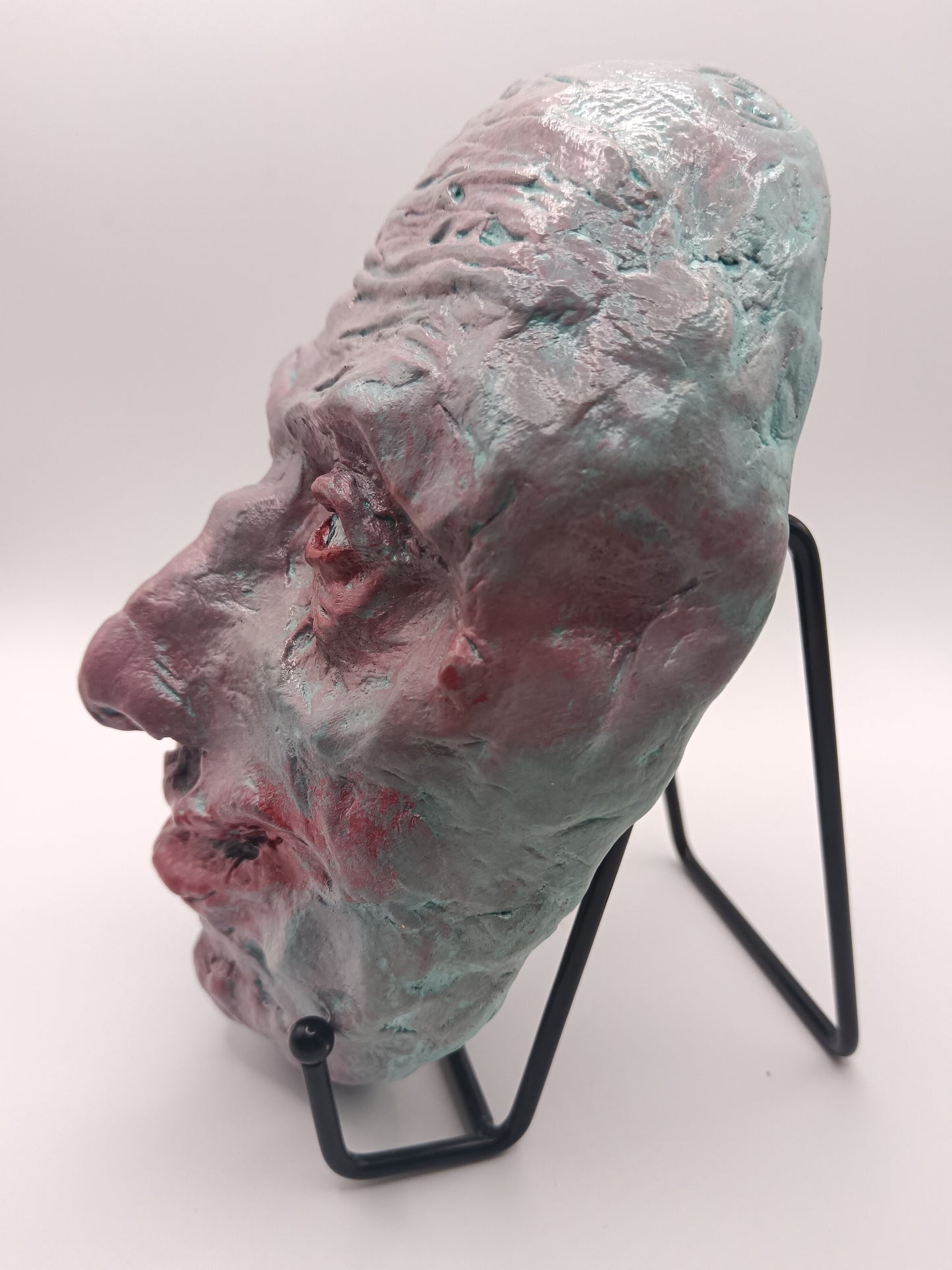 creepy grinning hand sculptured horror sculpture with stand left view