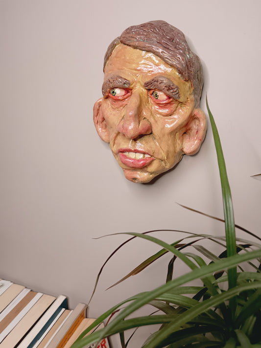 Hand sculpted clay yellow face mask sculpture wall mounted
