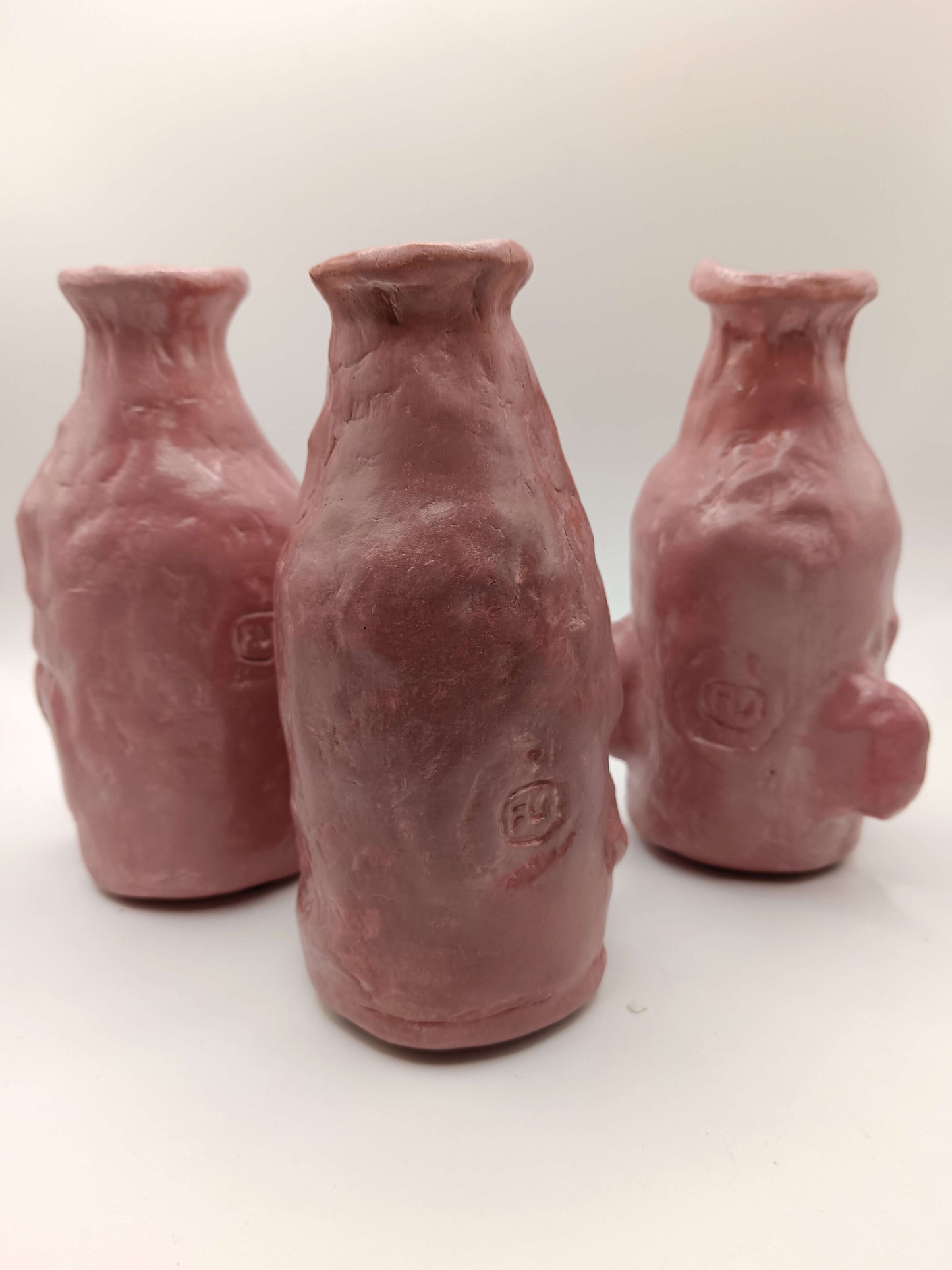 Three ceramic bottles with a textured surface on a white background