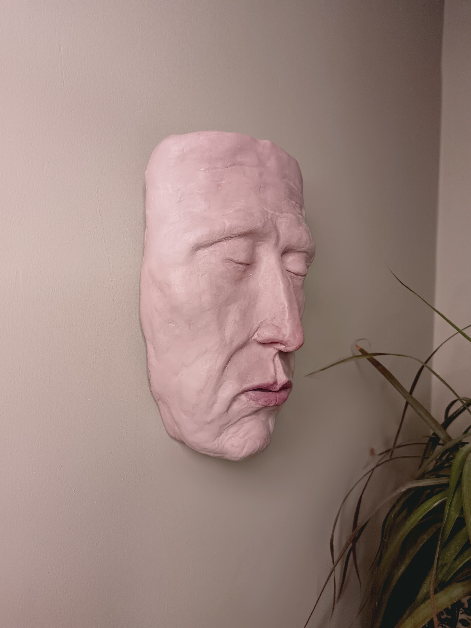 hand sculpted death mask sculpture wall mounted, side view 
