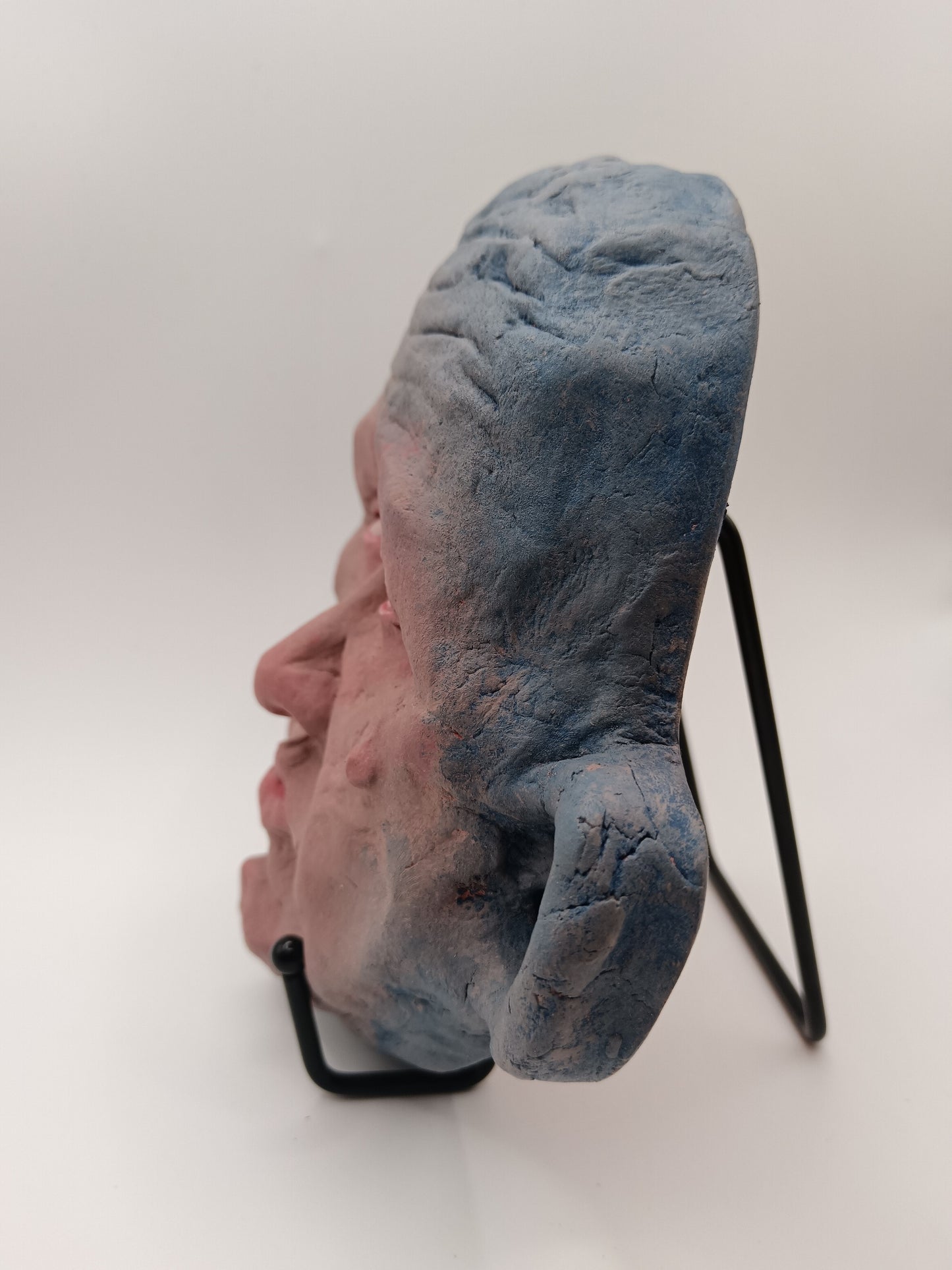 Blue face Handmade sculpture on stand, left view