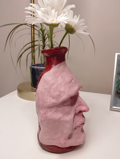 Handmade clay death mask vase, with flowers, side
