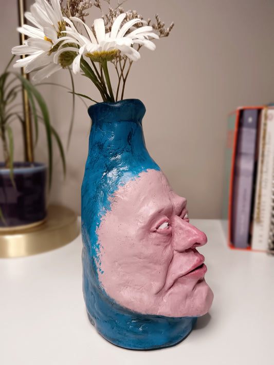 Hand sculpted blue face Vase - home setting - side view
