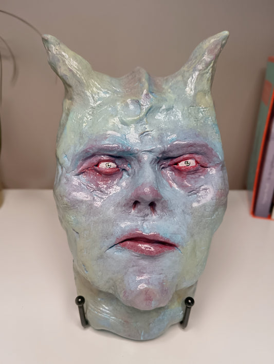 Francis underwater Monster mask with red eyes and horns on a white surface