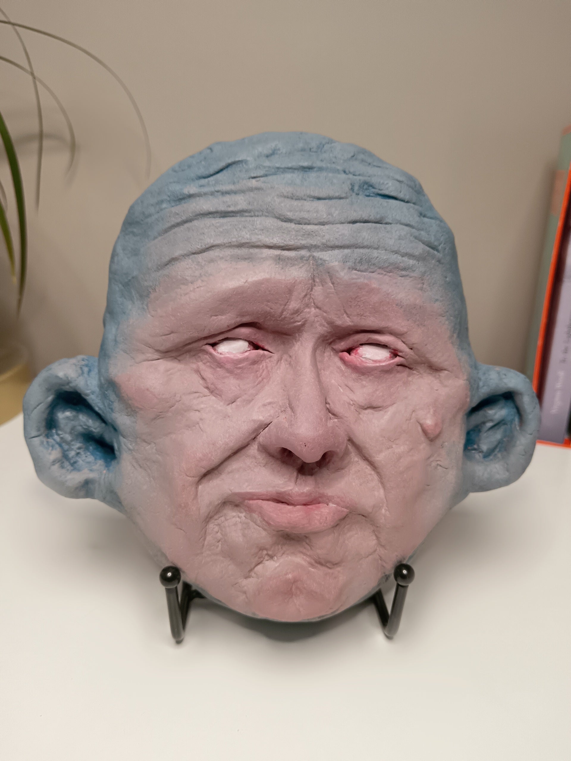 Blue face Handmade sculpture on stand, home setting